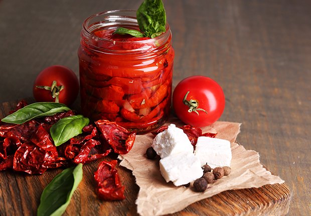 eingelegte Tomaten und Käse in Öl bewahren den Sommer im Glas