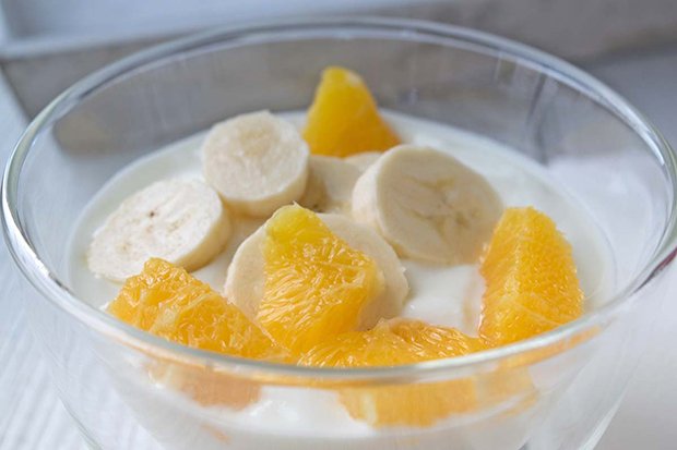 Frischer Joghurt-Becher mit Bananen und Orangen